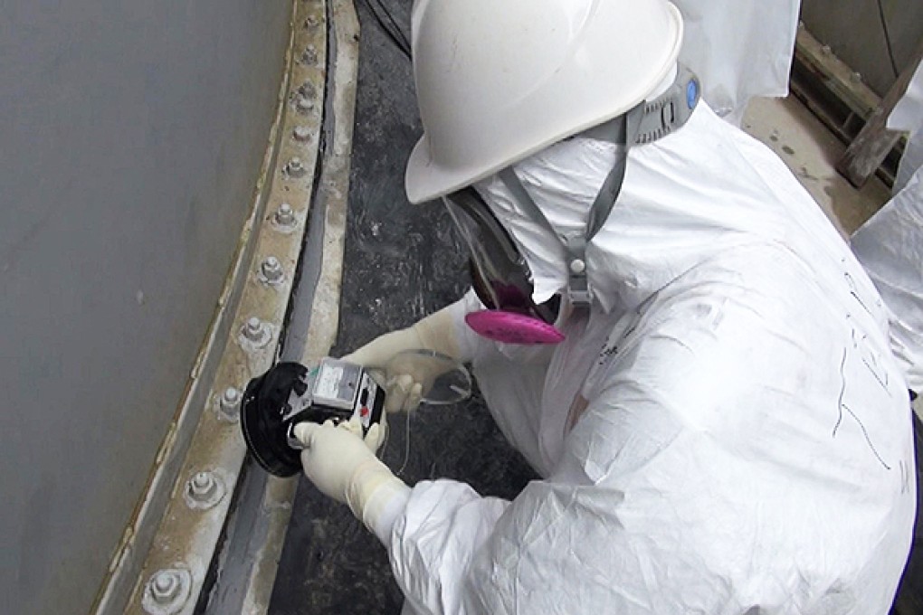 A Tepco worker checks radiation levels at the plant. Photo: AFP