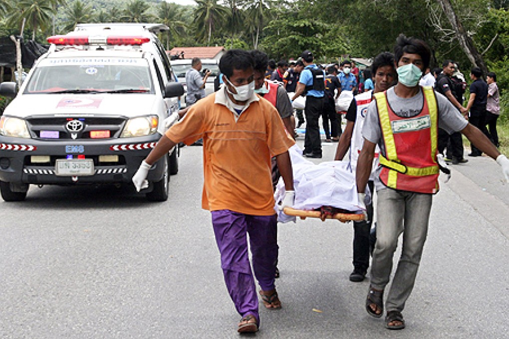 Rescue workers carry bodies after the fatal shooting of five police officers, in Tung Yang Daeng district of Pattani province, southern Thailand, on Wednesday. Photo: EPA