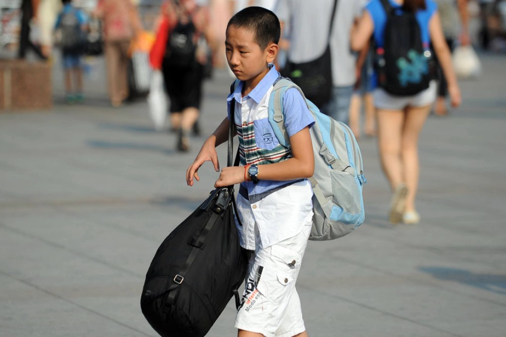 A boy walks into the Chongqing North Railway Station. Many children of migrant workers return to the places where they go to school as the summer vacation ends. Photo: Xinhua