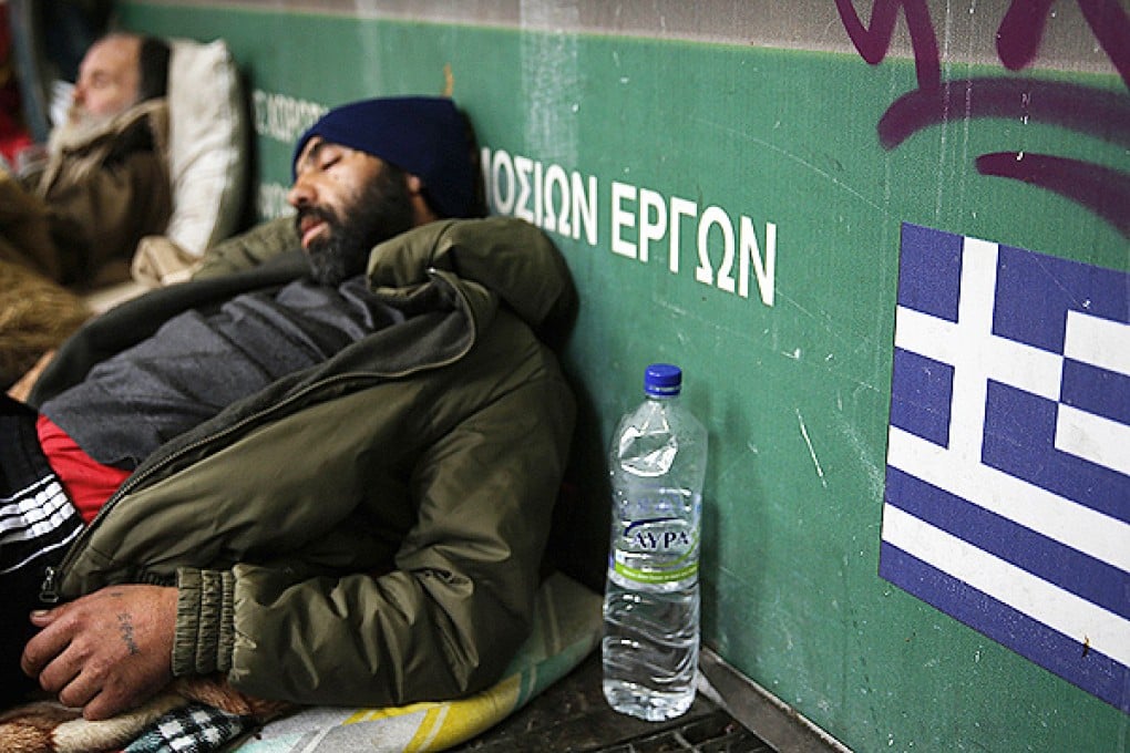 Homeless men sleep in the entrance of a metro station in central Athens. Photo: Reuters