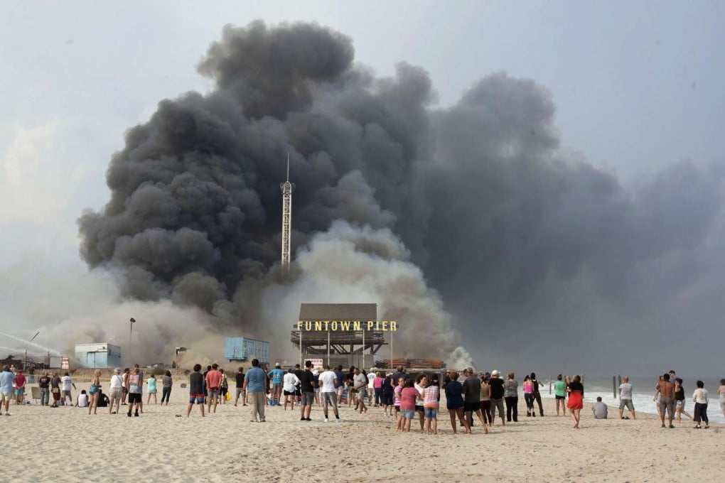 A huge cloud of black smoke rises above Funtown Pier. Photo: AP