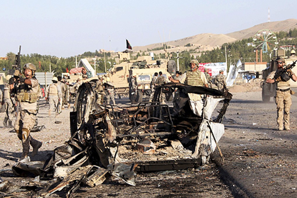 US-led troops investigate the site of a suicide car bombing and a gunfight near the US consulate in Herat province, west of Kabul, on Friday. Photo: AP