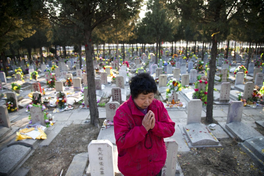 A woman prays at the grave of a loved one at the Babaoshan cemetery. An additional 10,020 urn niches to hold the ashes of party cadres and officials will be built. Photo: AFP