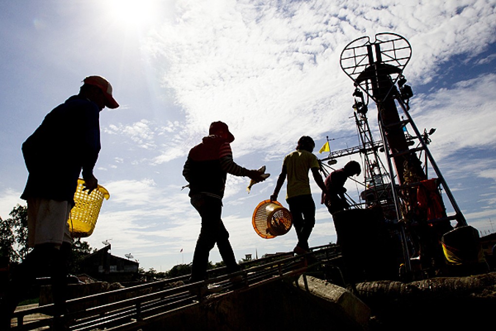 Migrant workers from Myanmar return to a trawler in the Gulf of Thailand. Photo: AP