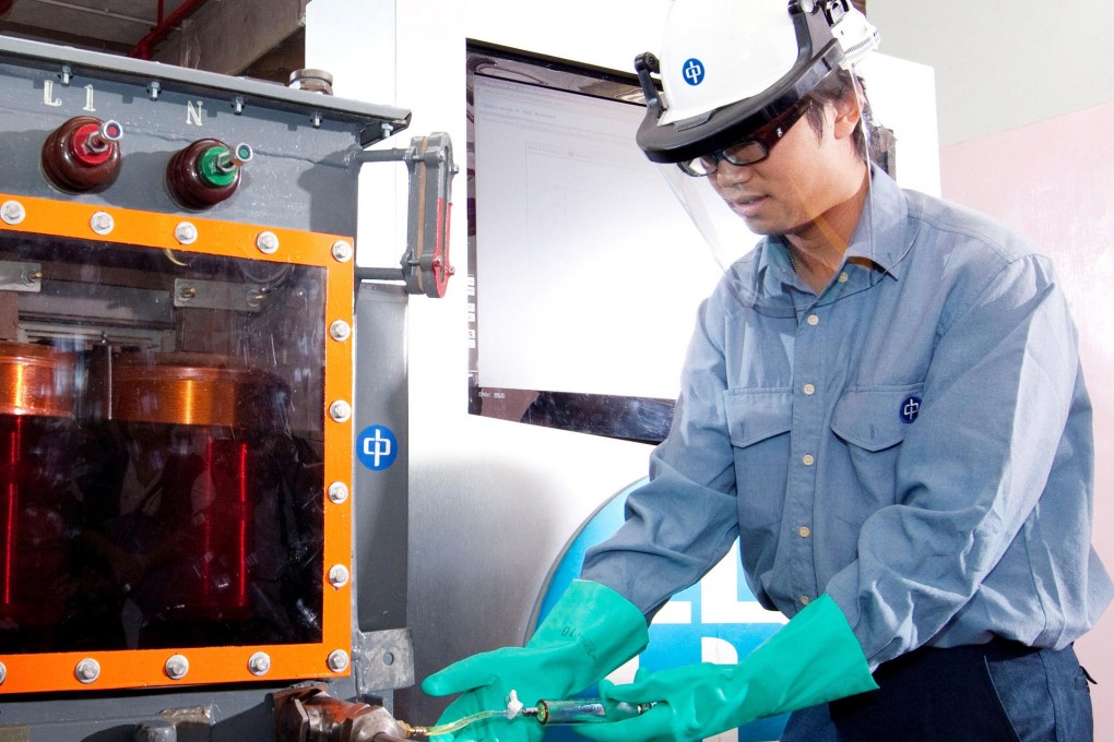 A technician examines a Dissolved Gas Analysis system.
