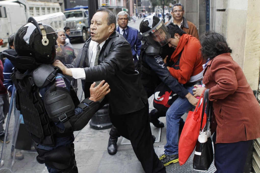 Riot police trying to make an arrest face a confrontation in Mexico City. Photo: Reuters