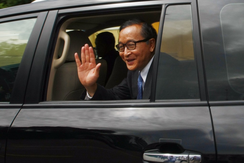 Cambodia's opposition leader Sam Rainsy waves from his car after a meeting in Phnom Penh. Photo: AP