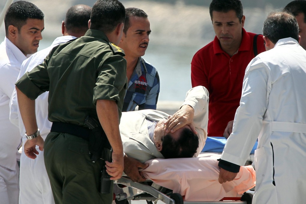 Former Egyptian President Hosni Mubarak, on a stretcher, is escorted into an ambulance to be taken by helicopter to the Police Academy in Cairo. Photo: EPA
