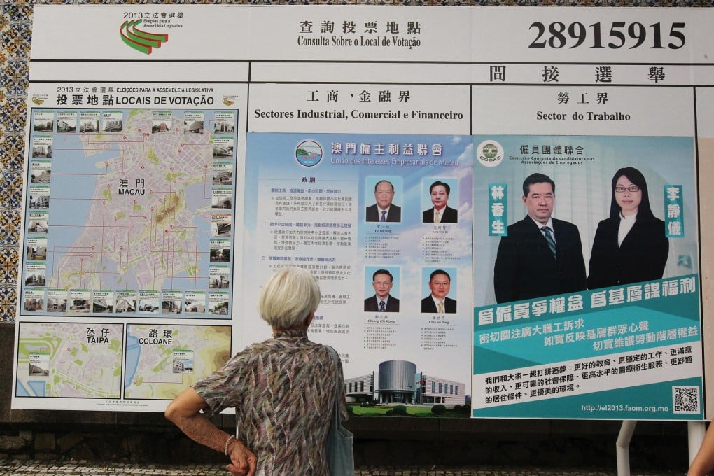 A woman looks at posters outside a polling place. Up to 12 voters were arrested yesterday for illegally taking pictures. Photo: KY Cheng