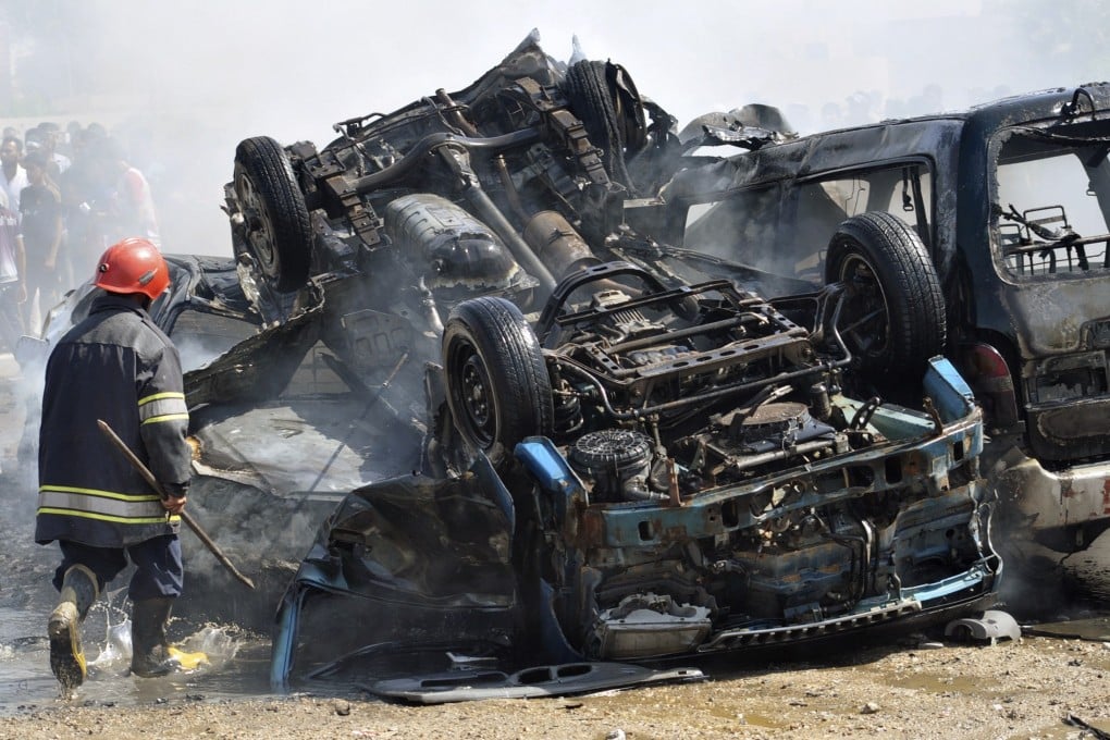 An Iraqi firefighter walks at the site of a bomb attack in Nasiriyah city.  At least 14 car bombs struck 11 towns and cities across Iraq on Sunday. Photo: Reuters