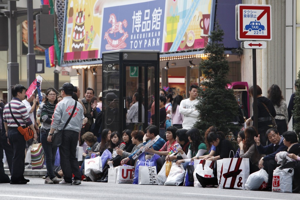 Chinese tourists take a break after shopping in Tokyo's posh Ginza district. Photo: AP