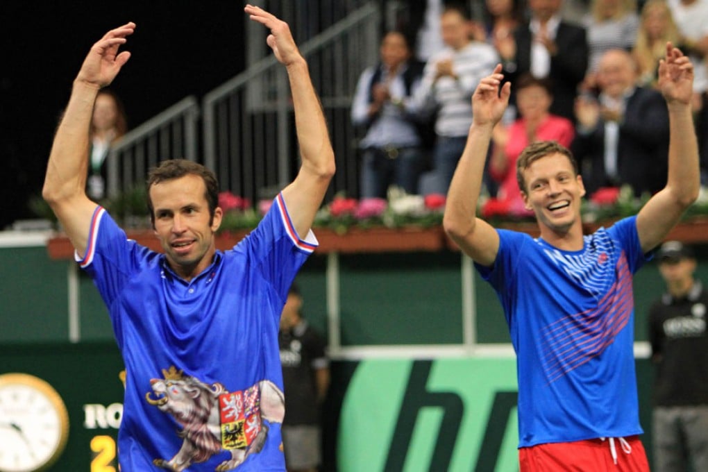 Czech Tomas Berdych (right) and Radek Stepanek (left) celebrate with team members after winning the third round of the Davis Cup semi-final tennis match. Photo: AFP