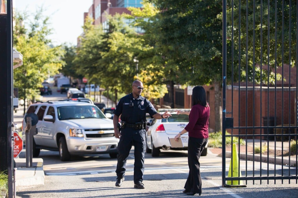 A police officer checks the ID of a person entering the Washington Navy Yard.