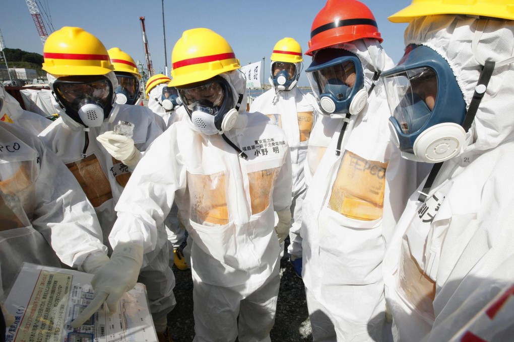 Clean-up plans were explained to Prime Minister Shinzo Abe, in red helmet, during his tour. Photo: EPA