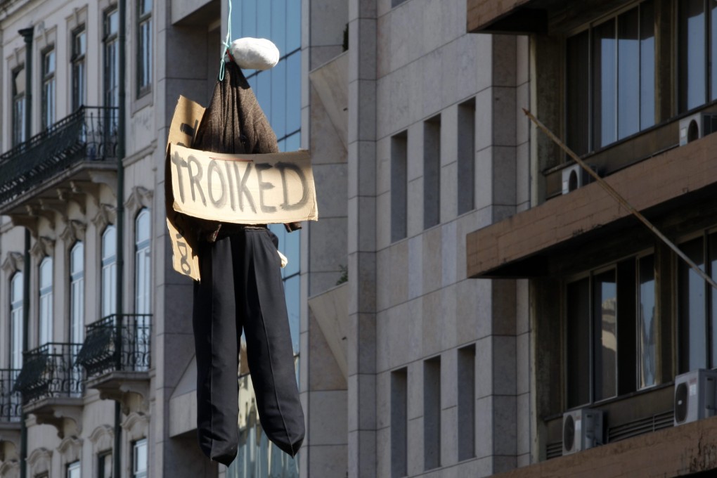 A puppet dangles from a traffic light pole, in protest against this week’s inspection visit by the so-called troika of lenders representing the European Union, the International Monetary Fund and the European Central Bank. Photo: EPA