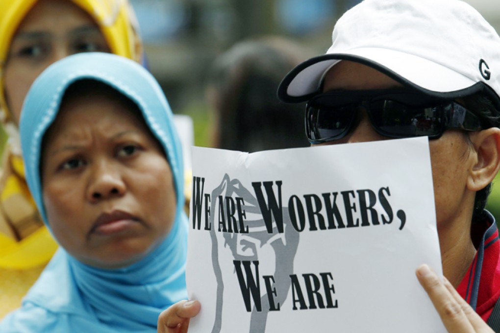 Domestic helpers rally in support of an Indonesian maid who was tortured by her employers, outside Wanchai District Court in Hong Kong. Photo: Reuters