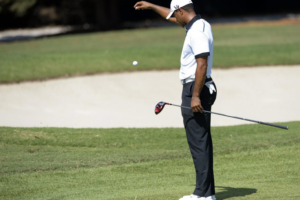 Tiger Woods takes a drop at East Lake during his second round on Friday - no rules violation here, his ball landed on a sprinkler head, but his round imploded over the last five holes. Photo: EPA