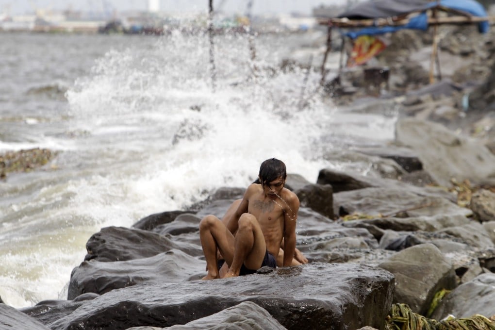 A Filipino braves strong waves at a coastal village in Pasay city, south of Manila, Philippines, as Super-Typhoon Usagi hits the region. On Saturday, Usagi was approaching Hong Kong. Photo: EPA