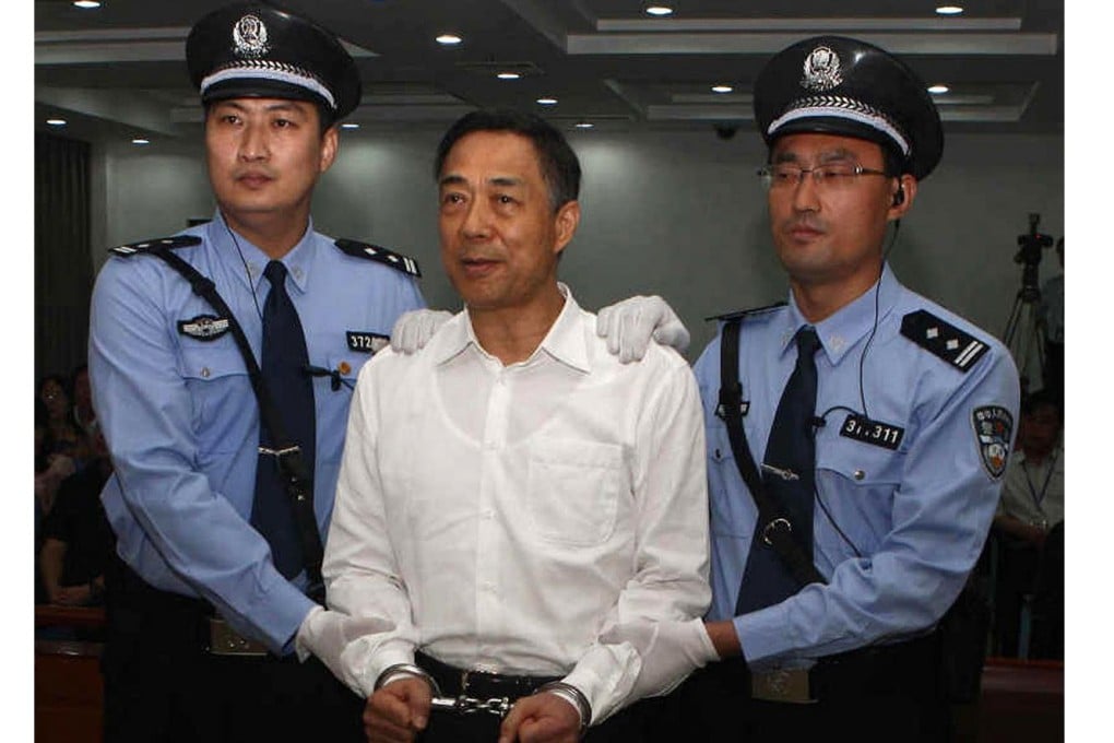 Former Chinese political star Bo Xilai (centre) stands in a courtroom in Jinan wearing a pair of handcuffs. Photo: AFP