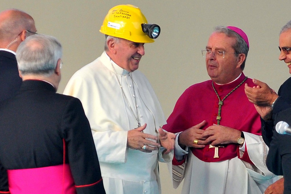 Pope Francis wears a helmet from a coal miner in Sardinia. Photo: AP