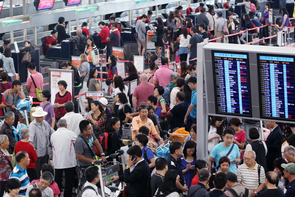 Hundreds of passengers mill about in limbo at Chek Lap Kok yesterday afternoon, frustrated and confused about their disrupted travel plans. Photo: K.Y. Cheng