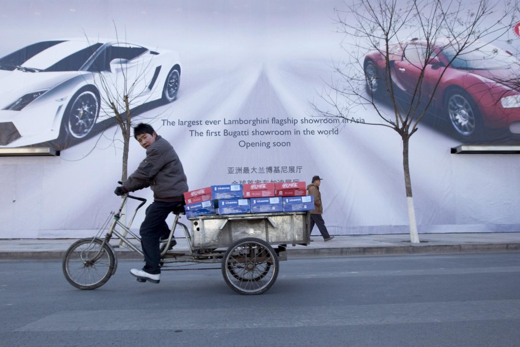 Cyclists pass an advertisement for a soon to be opened saleroom for Bugatti and Lamborghini supercars in Beijing. Photo: EPA
