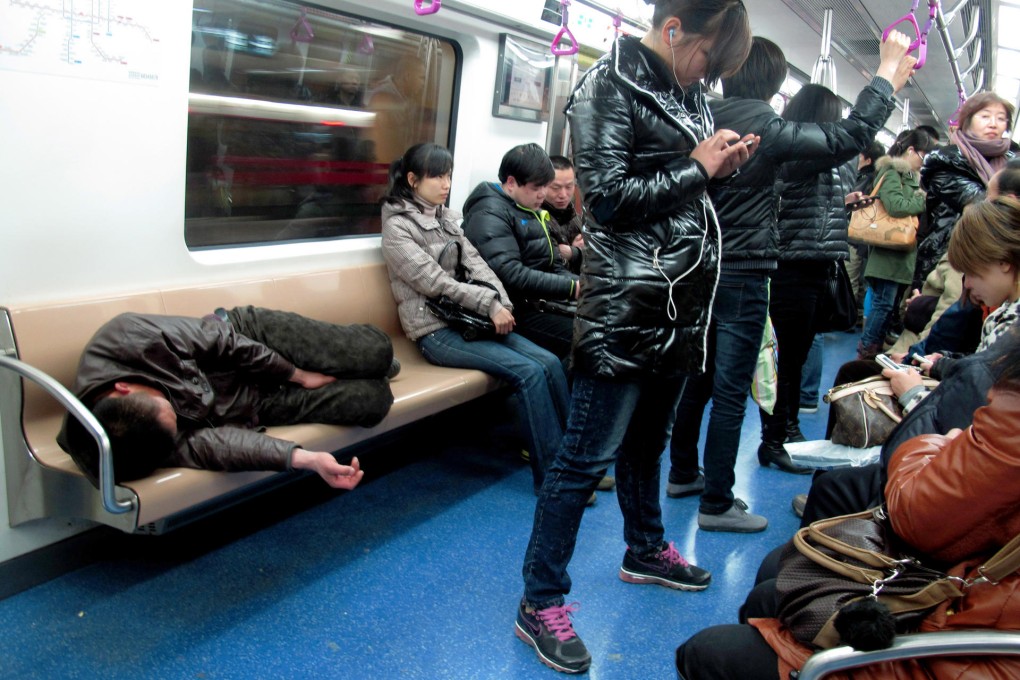 A man sleeps on a subway train in Beijing. Photo: China Foto Press