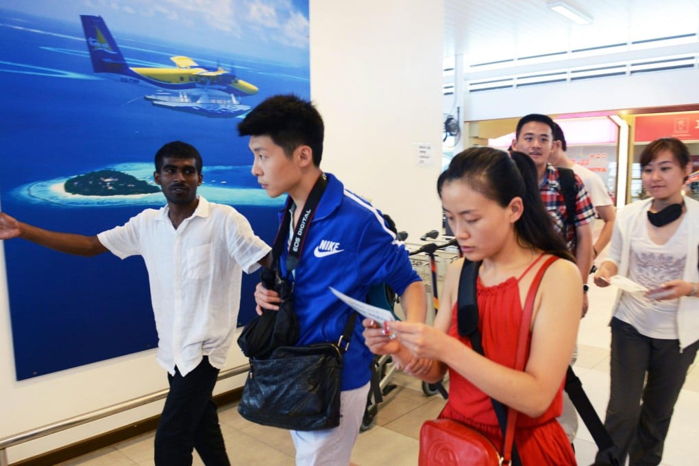 A Maldivian hotel guide (left) directs arriving Chinese tourists, who make up nearly a quarter of the island nation's visitors. Photo: AFP