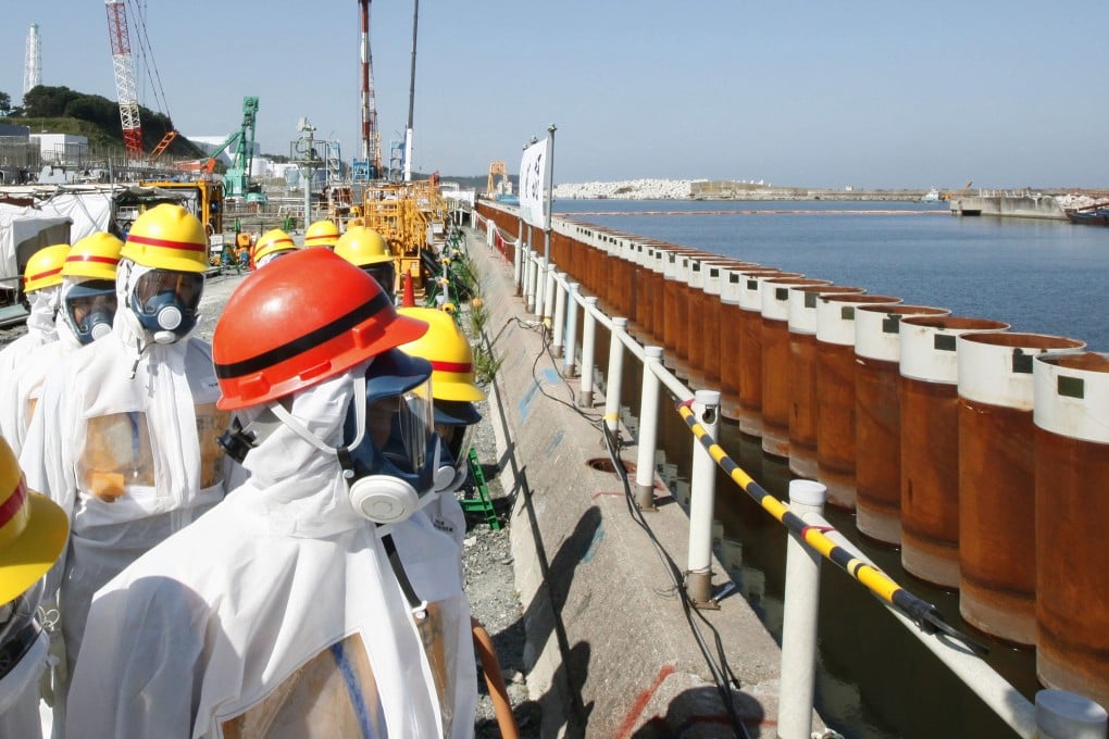Japanese Prime Minister Shinzo Abe inspects a water barrier at the Fukushima nuclear plant. Photo: AP