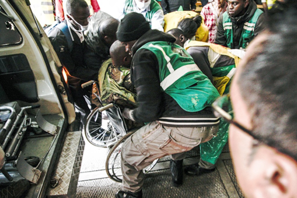 A member of the Kenyan defence forces who was wounded after a gunfire exchange with the Al-Shabab militants is carried to safety from the Westgate shopping mall. Photo: EPA