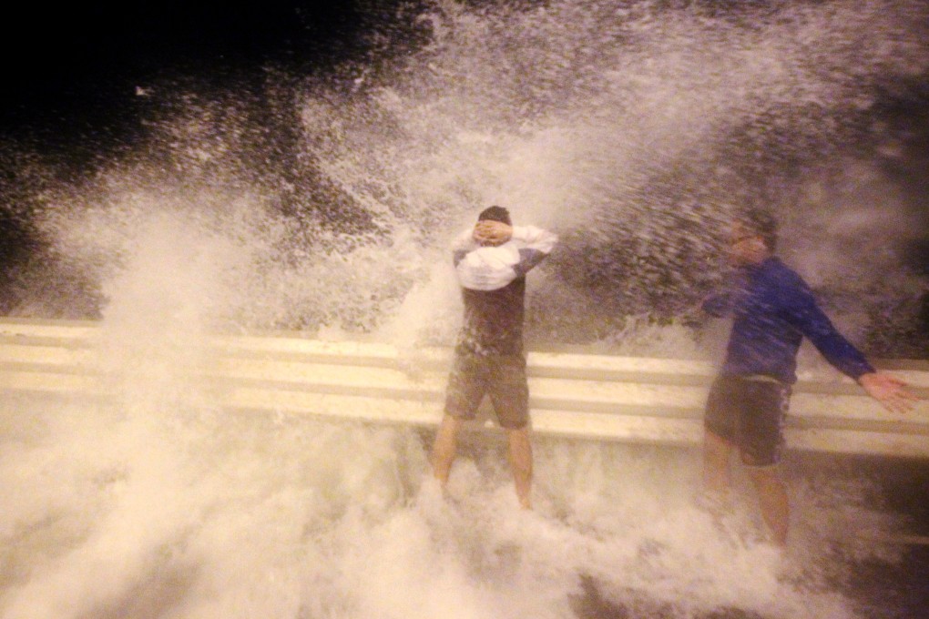 People brave waves in Kennedy Town under typhoon signal no 8. Photo: Felix Wong