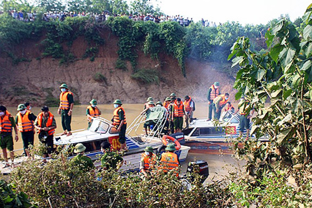 Rescuers search for bodies of victims who drowned after their van became flooded in a river in Nam Dan district, central Nghe An province in Vietnam. Photo: AFP