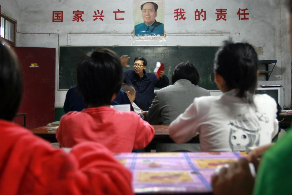 Democracy School principal Xia Zuhai holds a copy of Mao Zedong's little red book as he delivers a speech during morning class on September 9, the 37th anniversary of Mao's death. The slogan on the wall says: "The country's rise and fall is my responsibility."