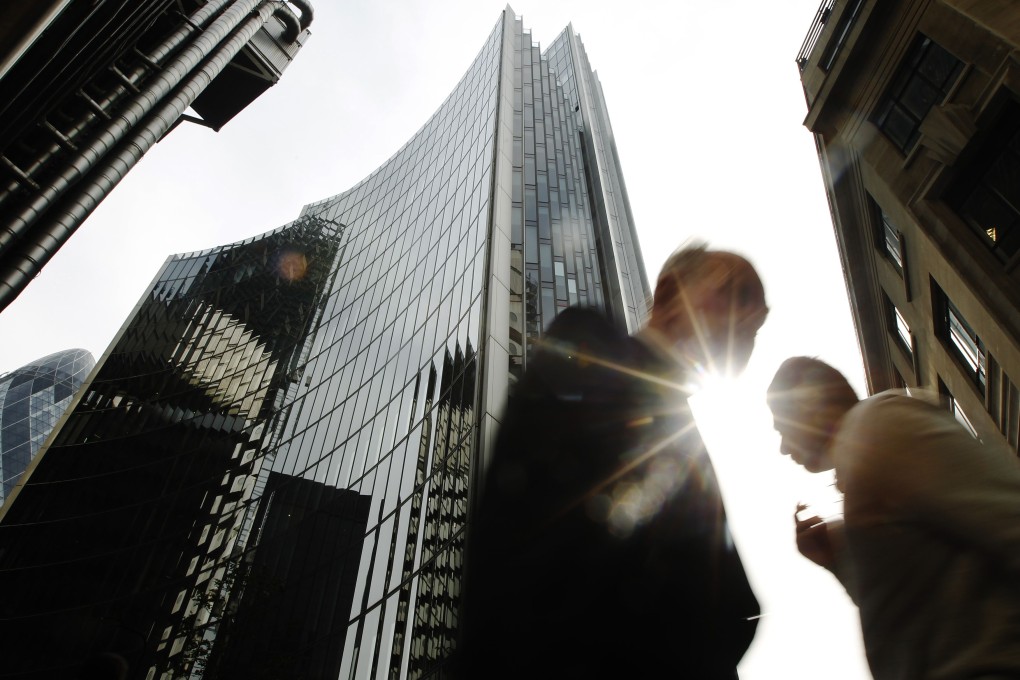 Pedestrians pass office blocks in the City of London June 19, 2013. Photo: Reuters