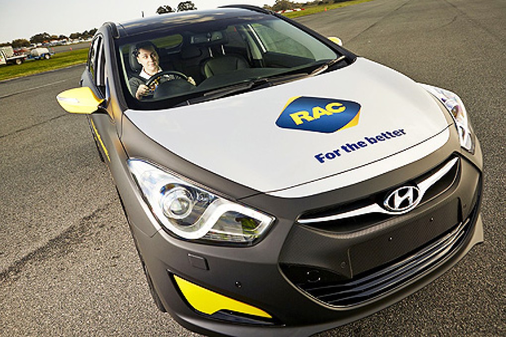 A driver wearing a headset designed to raise awareness about the deadly impact of inattention on roads sits in the world’s first attention powered car. Photo: AFP