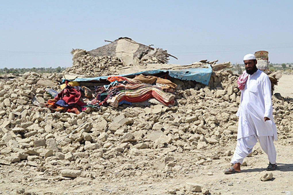 A man passes by rubble of his destroyed home in Awaran, Balochistan province, Pakistan, on Wednesday. Photo: EPA