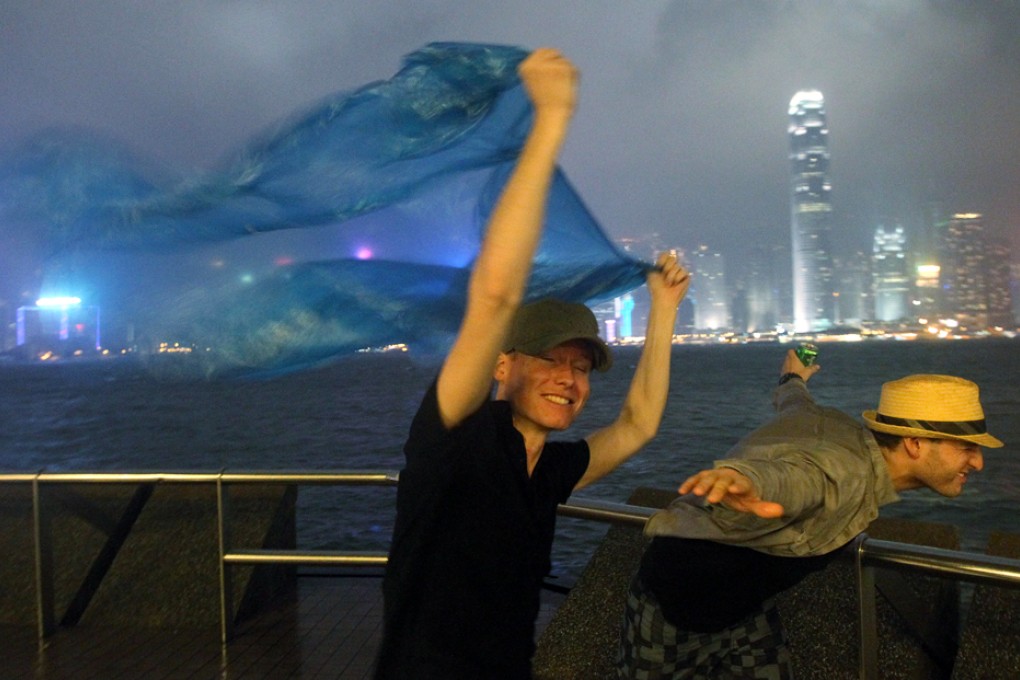 People brave stormy weather near Star Ferry Pier in Tsim Sha Tsui under typhoon signal no. 8 as typhoon Usagi hits Hong Kong. Photo: Felix Wong