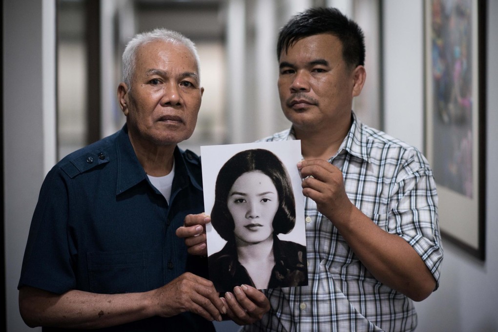A picture of Anocha Panjoy, who disappeared in 1978, is held by her brother Sukham Panjoy and nephew Bangjong Panjoy. Photo: AFP