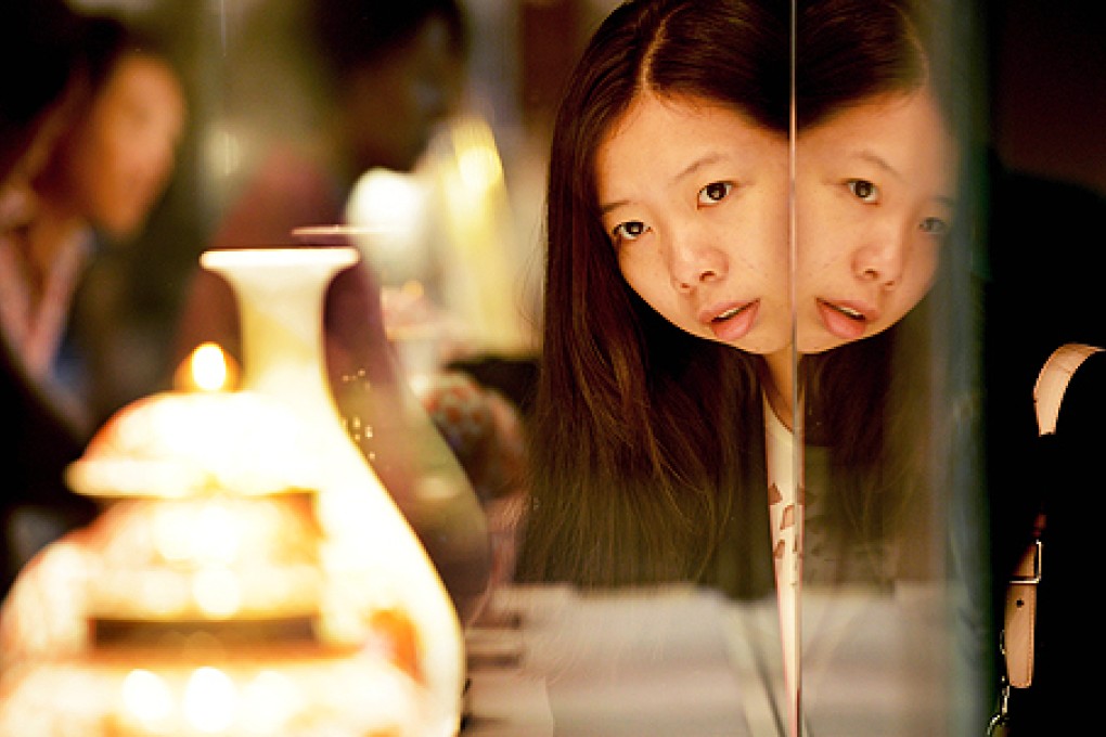 A visitor looks at Chinese porcelain at a preview of a Christie's auction in Shanghai on Tuesday. Photo: AFP