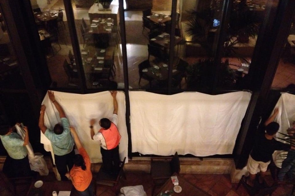 Guam Hilton workers cover the site of the explosion. Photo: AP