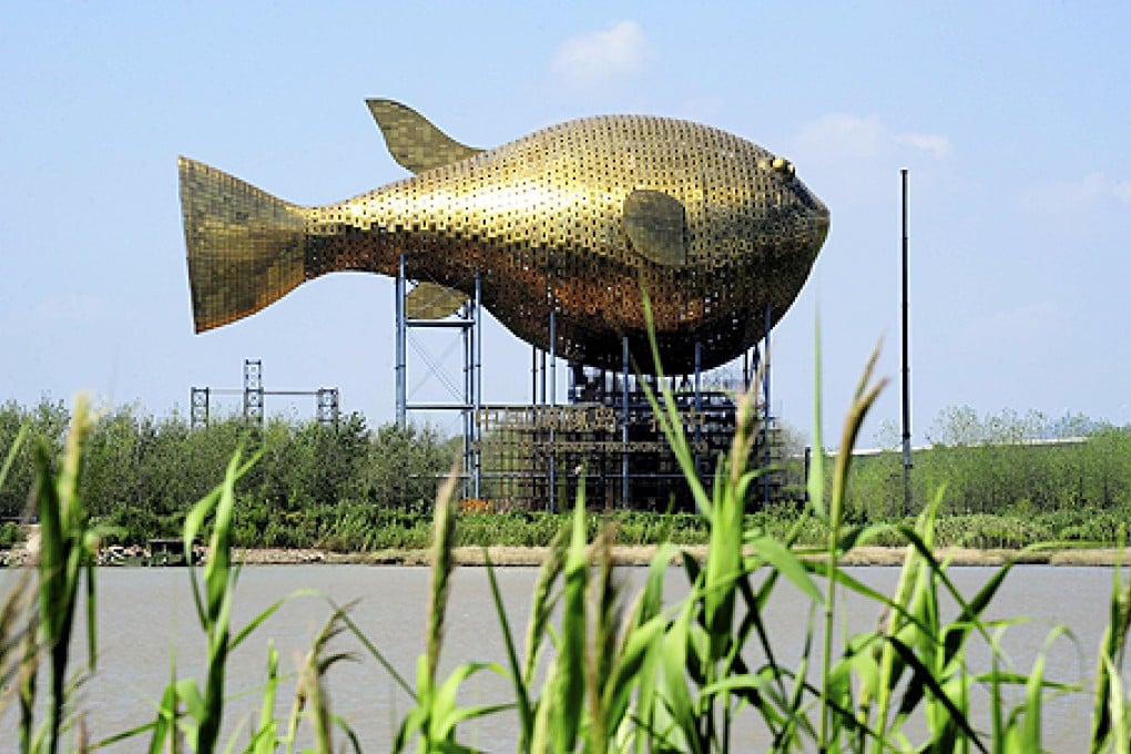 Viewing tower in the shape of a giant copper puffer fish is seen under construction on the banks of a river in Yangzhong county. Photo: Reuters