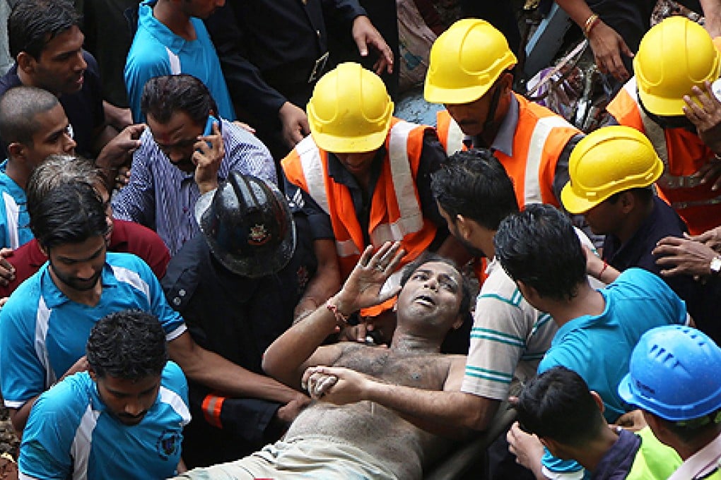 A survivor is rescued from the rubble after residential building collapsed in Mumbai, India, on Friday. Photo: EPA