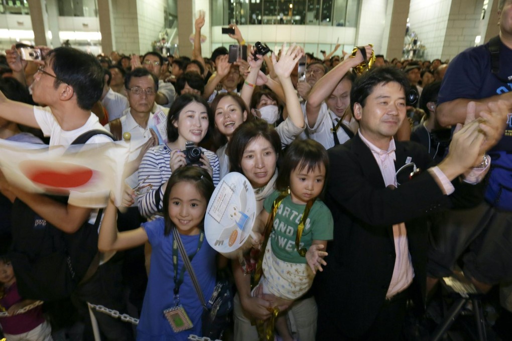 Tokyo residents cheer the Olympic decision. Photo: EPA