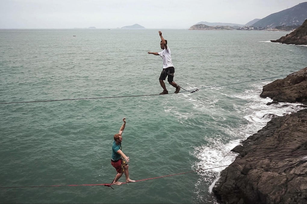 Rio Zhang and Shane Yates highlining at Cape Collinson, suspended 20 metres above the sea. Photos: Pure Slacklines and DJI