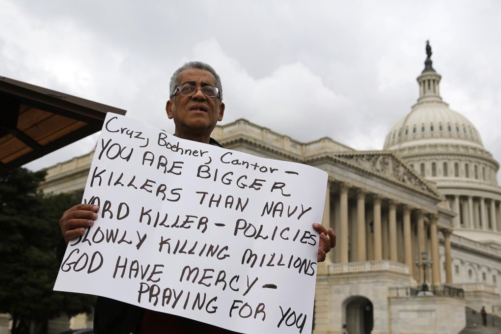 A protester outside the US Capitol building in Washington blasts Republicans for trying to derail Obamacare. Photo: Reuters