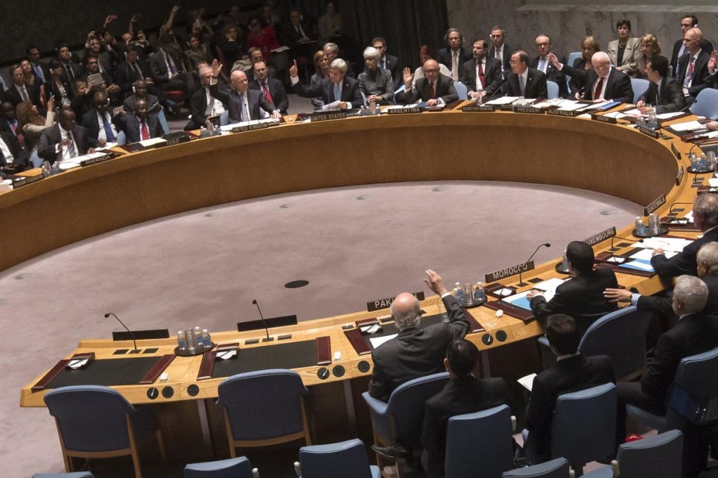 Members of the UN Security Council raise their hands as they vote to approve a resolution eliminating Syria's chemical arsenal. Photo: Reuters