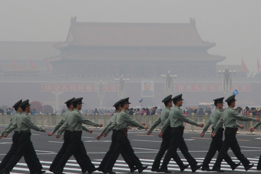 Guards march at Tiananmen Square as air pollution typical of winter affected the city. Photo: Xinhua