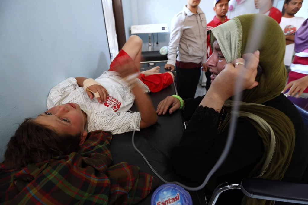 Nadine Bakour, a Lebanese woman who lost her husband and two sons in the boat sinking, cries next to her son Khalil el Rahi at Agrabinta health clinic in Indonesia's West Java province. Photo: Reuters