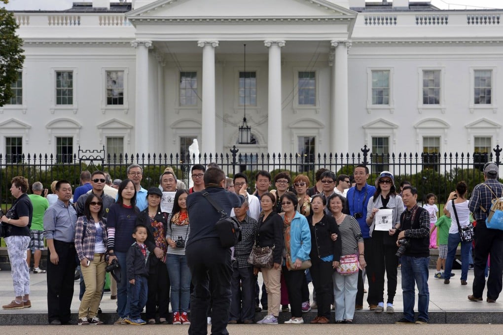 Chinese tourists have their photograph taken outside the White House as a possible US government shutdown looms. Photo: Reuters