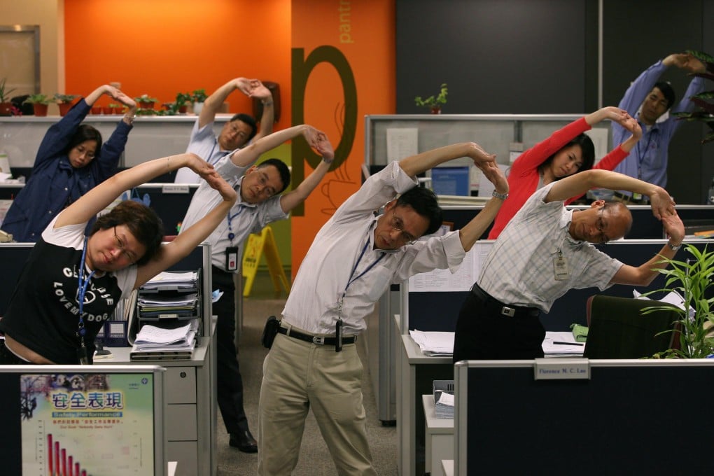 CLP Power employees perform a 15-minute stretching session at their desks. Photo: Oliver Tsang